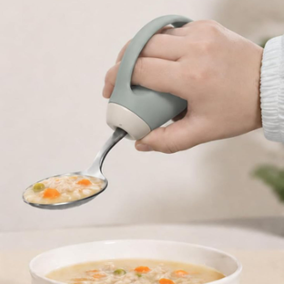Hand holding a spoon of soup steadily with the anti-shake utensil grip handle